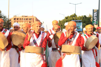 Troupe en costumes rouges et tambours lors de la parade du Festival National des Arts Populaires de Marrakech