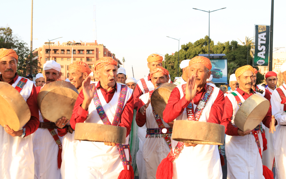 Troupe en costumes rouges et tambours lors de la parade du Festival National des Arts Populaires de Marrakech