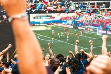 Foule de supporters regardant un match de football sur grand écran (illustration)