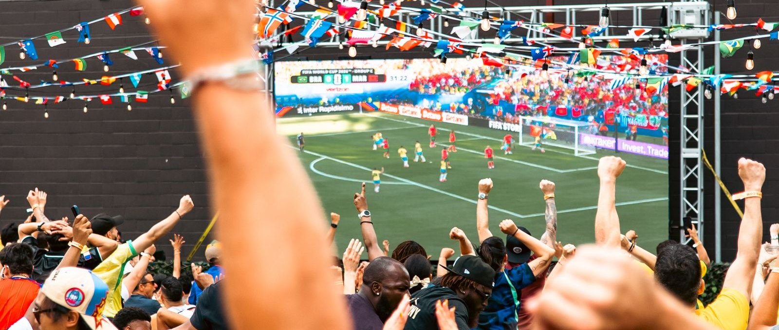 Foule de supporters regardant un match de football sur grand écran (illustration)